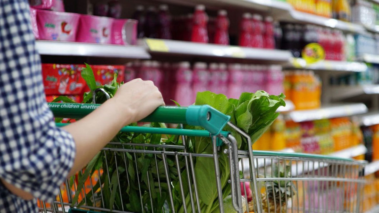 Una mujer empujando un carro de supermercado